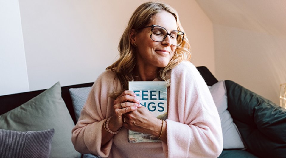 En lykkelig forfatter, der holder sin egen bog i hænderne for første gang